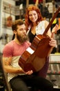 Couple of musicians with guitar at music store