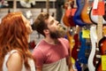 Couple of musicians with guitar at music store