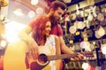 Couple of musicians with guitar at music store