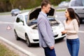 Couple near broken car on a highway roadside Royalty Free Stock Photo