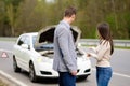 Couple near broken car on a roadside Royalty Free Stock Photo