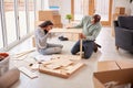 Couple In New Home On Moving Day Putting Together Self Assembly Furniture Royalty Free Stock Photo