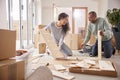 Couple In New Home On Moving Day Putting Together Self Assembly Furniture Royalty Free Stock Photo