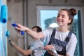 Couple in new home during repair works painting wall together. Happy family holding paint roller painting wall with blue Royalty Free Stock Photo