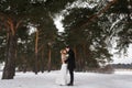 Couple newlyweds walking in a winter forest