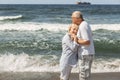 A couple of nice old people. The man holds the woman's hands. she puts her head on his chest