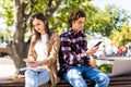 Couple not talking to each other typing on mobile phones sitting in the bench on the street Royalty Free Stock Photo