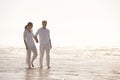 Couple, ocean and holding hands on beach, travel and commitment with trust and bonding with walking outdoor. Love, care Royalty Free Stock Photo