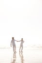 Couple, ocean and holding hands for walk on beach, travel and commitment with trust and bonding outdoor. Love, care and Royalty Free Stock Photo