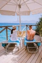 Couple by the ocean on sunbed by the ocean on the beach of Crete Greece