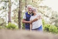 Couple of ol caucasan people mature man and woman hug together in. relationship - outdoor leisure activity for active senior - Royalty Free Stock Photo