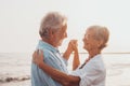 Couple of old mature people dancing together and having fun on the sand at the beach enjoying and living the moment. Portrait of Royalty Free Stock Photo