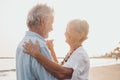 Couple of old mature people dancing together and having fun on the sand at the beach enjoying and living the moment. Portrait of Royalty Free Stock Photo