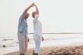 Couple of old mature people dancing together and having fun on the sand at the beach enjoying and living the moment. Portrait of Royalty Free Stock Photo