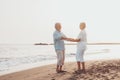 Couple of old mature people dancing together and having fun on the sand at the beach enjoying and living the moment. Portrait of Royalty Free Stock Photo