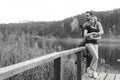 A couple on the old wooden bridge at a lake on autumn day in park. Forest on background. Happy togather, copy space for text. Royalty Free Stock Photo