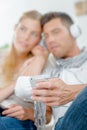 Couple out focus listening to headphones from cellphone Royalty Free Stock Photo