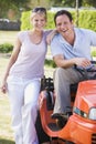 Couple outdoors with lawnmower smiling Royalty Free Stock Photo