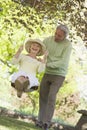 Couple outdoors with tree swing smiling Royalty Free Stock Photo