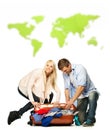 Couple packing suitcase against world map Royalty Free Stock Photo