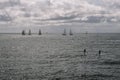 Couple paddleboarding and Sailboats On Sea Against Cloud Sky