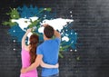 Couple painting a Colorful Map with paint splatters on wall background Royalty Free Stock Photo