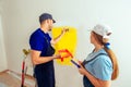 Couple painting wall at home in yellow color Royalty Free Stock Photo