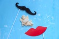 Couple paper mustache and lips props on stick and figurine of little Cupid holding heart Royalty Free Stock Photo