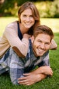 Couple, park and grass with smile, portrait and love for date and relationship or bonding. Man, woman and nature with