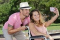 couple in park taking selfie woman in wheelchair Royalty Free Stock Photo