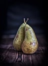 Couple pears on old rustic wooden table background, dark toned s