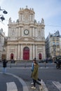 A Couple of pedestrians walking on the zebra crossing in front of the Parish Church of Saint-Paul of Saint-Louis