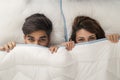 Couple peeking under sheets