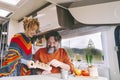 Couple of people enjoy leisure indoor in a camper camping car. Adult man and woman smile and have fun during travel vacation or Royalty Free Stock Photo