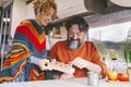 Couple of people enjoy leisure indoor in a camper camping car. Adult man and woman smile and have fun during travel vacation or Royalty Free Stock Photo