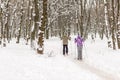 Couple of people enjoying cross-country skiing in city park or forest in winter. Family Sport outdoor activities in winter season Royalty Free Stock Photo