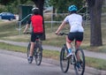 A couple of people riding their bicycles on a busy street during summer. Concept: Cycling Royalty Free Stock Photo