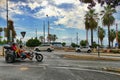 Couple of people riding on vintage three-wheel motor bike with a passenger seat driving on a street