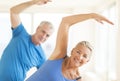 Couple Performing Stretching Exercise At Home