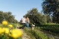 Couple with pet ,golden retriever dog, walking along path across field in countryside Royalty Free Stock Photo