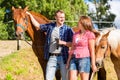 Couple petting horse on pony stable