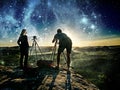 Couple of photographers working together on the rocky view point Royalty Free Stock Photo