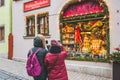 Couple photographing shop window brightly decorated for Christmas in Rothenburg ob der Tauber in Germany