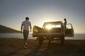 Couple By Pick-Up Truck Parked On Beach Royalty Free Stock Photo