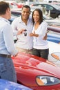 Couple picking up new car from salesman Royalty Free Stock Photo