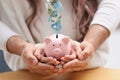 Couple with piggy bank at table, closeup