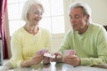 Couple playing cards in living room smiling Royalty Free Stock Photo