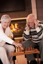 Couple playing chess in cosy living room