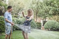 Couple playing with a garden hose and spraying each other outside in the garden Royalty Free Stock Photo