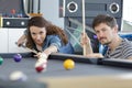 couple playing pool with woman taking aim Royalty Free Stock Photo